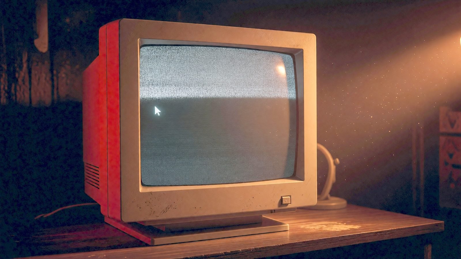 Gros plan sur un écran d'ordinateur qui diffuse une lueur dans une pièce sombre, éclairée par une lampe de bureau.