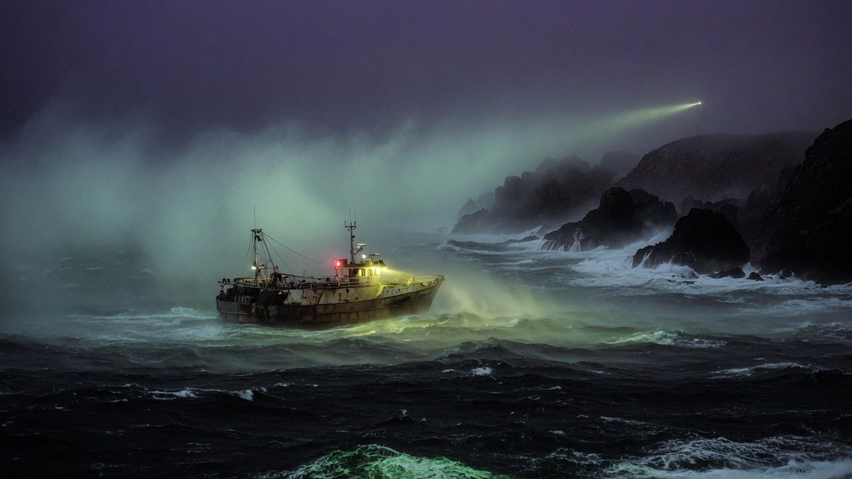 Bateau de pêche isolé dans le brouillard nocturne sur une mer sombre et inquiétante