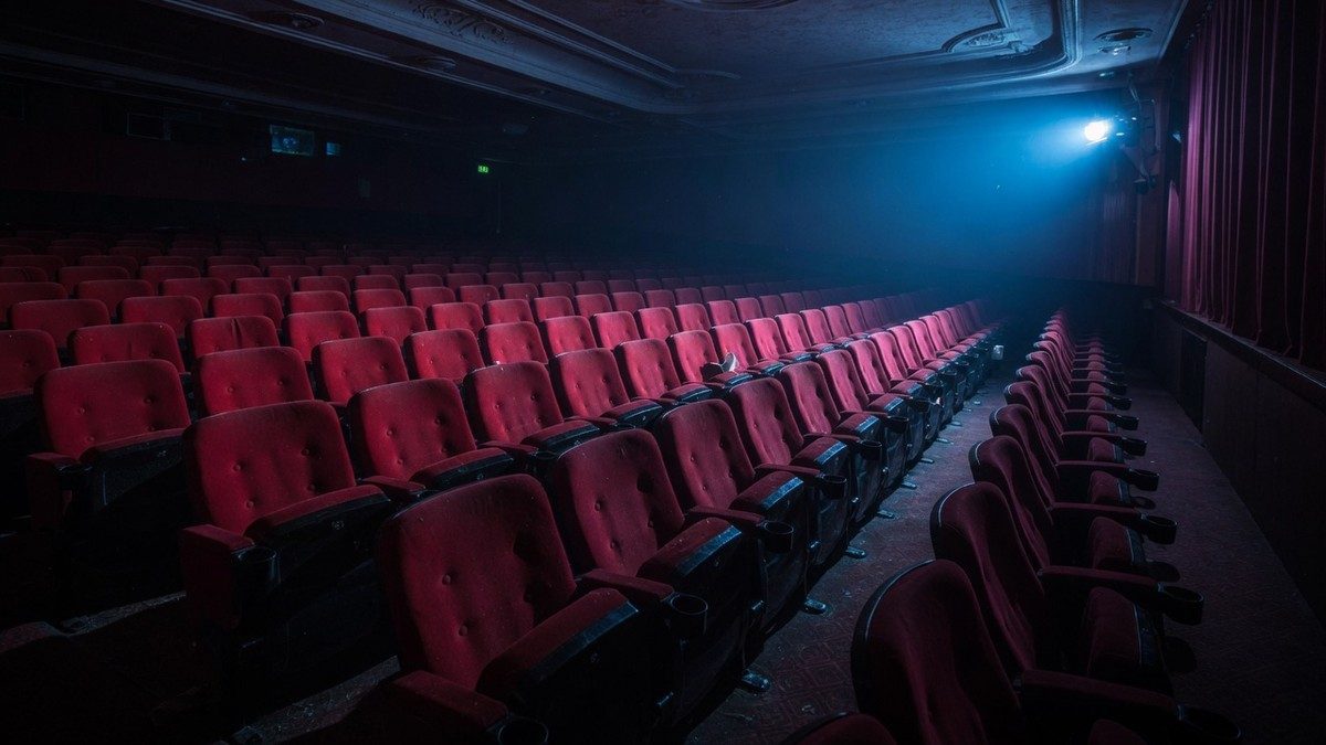 Salle de cinéma vide baignée d'une lumière bleutée, ambiance mystérieuse