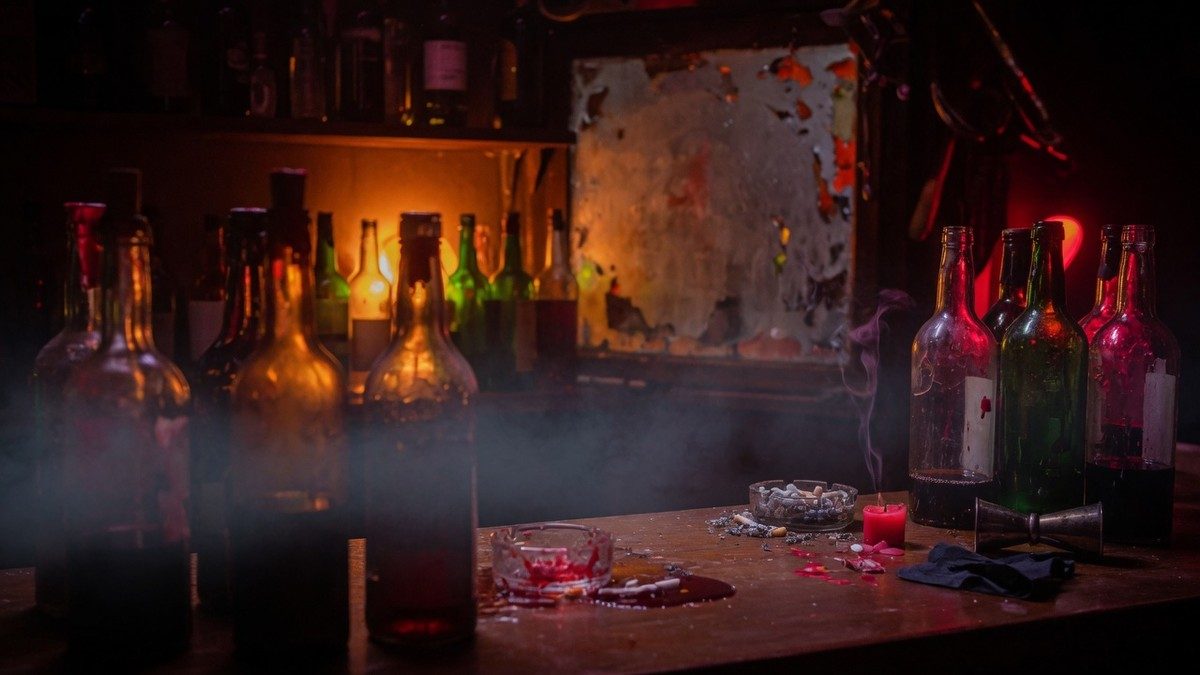 Ambiance de bar sombre avec des bouteilles en verre éclairées par une lumière orangée et rouge, évoquant une atmosphère d'horreur