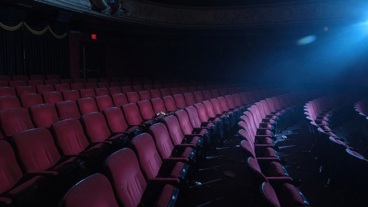 Salle de cinéma vide baignée d'une lumière bleutée, ambiance nocturne d'Halloween