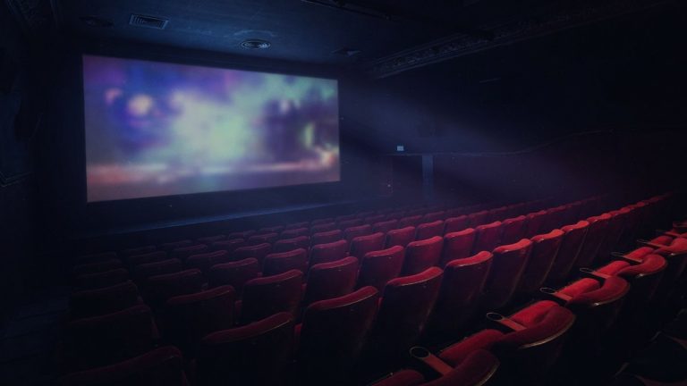 Salle de cinéma vide plongée dans une ambiance sombre et mystérieuse