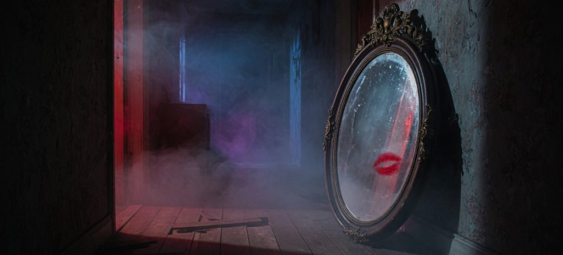 Couloir sombre et brumeux avec un miroir ancien reflétant une lueur rouge inquiétante