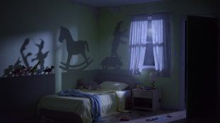 Chambre d'enfant plongée dans l'obscurité à 3h du matin, jouets projetant des ombres inquiétantes, porte entrouverte sur un couloir noir